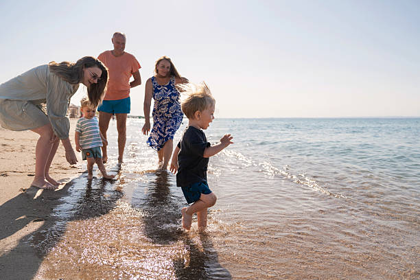 istock Happy multi-generation family having fun on a sandy beach 2235830964