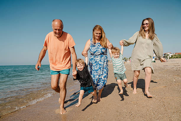 istock Happy multi-generation family having fun on a sandy beach 2235830999