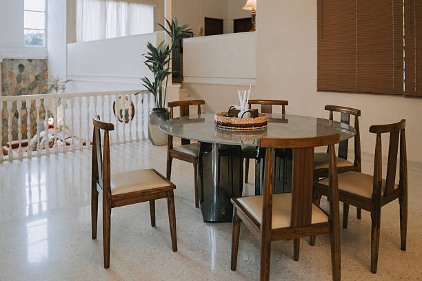 istock Modern dining area with round stone table and wooden chairs 2235834371
