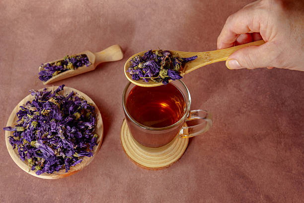 istock Herbalist adding dried mallow flowers to a tea infusion using wooden spoon 2235849688