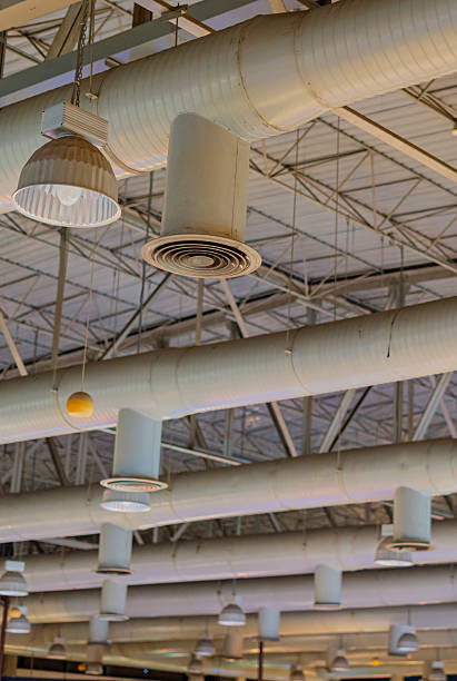 istock Air conditioning ducts on the ceiling of a large building hall 2235851524
