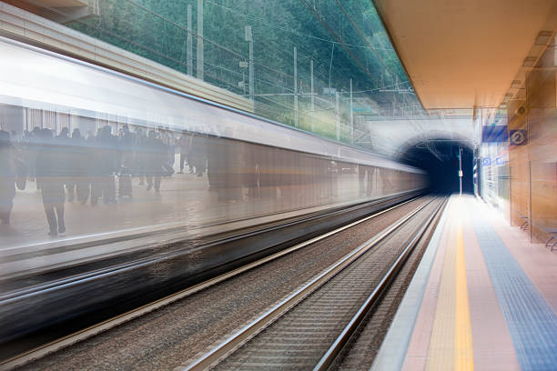 Motion blurred passenger train entering railway tunnel