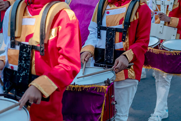 istock Close-up of marching band drummers in colorful uniforms playing snare drums during a parade, showing rhythm, teamwork, and vibrant festive spirit. 2235856415