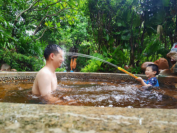 Father and son are playing in the hot spring pool