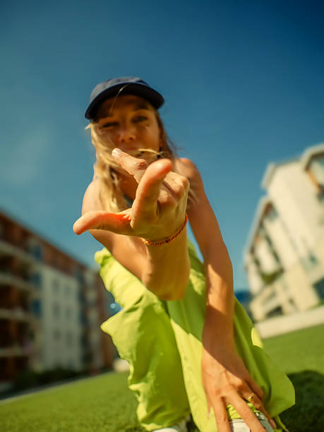 Happy African American woman throwing flying disk against blue sky on sunny day