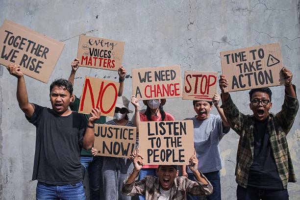 istock Group Of Diverse People Holds Up Protest Signs 2235858747