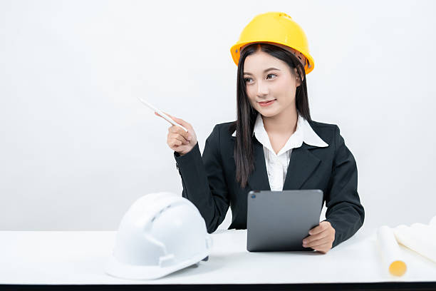 istock The studio shot with a white background portrays an Asian female engineer at her desk, using a tablet and greenprint to highlight industry innovation and promote her company on social media. 2235859767