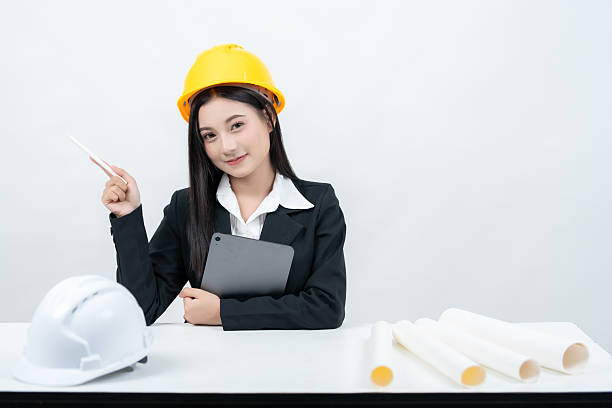 istock An Asian female engineer appears in a studio shot with a white background, working at her desk with a tablet and greenprint, showcasing how the industry embraces digital growth on social media. 2235859774