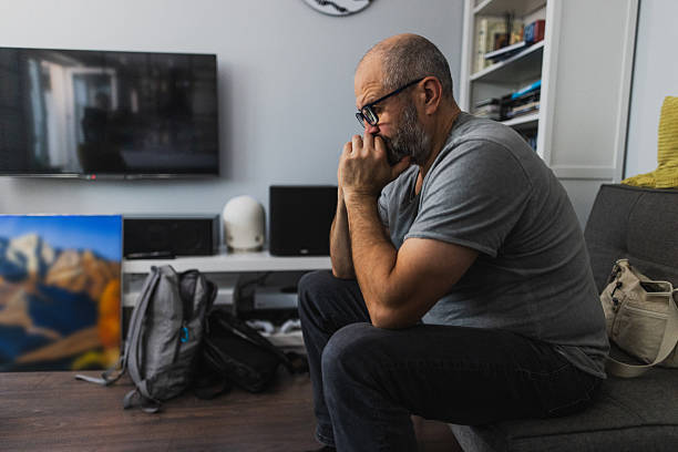 istock Man Sitting on Floor Holding Head in Thoughtful Moment. He has problems in his life 2235861453