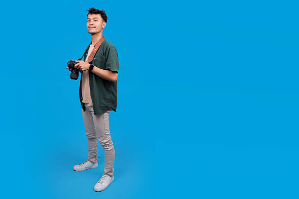 istock Smiling Young Male Photographer Holding A Digital Camera 2235861608