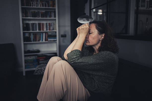 istock Woman Sitting Alone on a Sofa Looking Stressed 2235861797