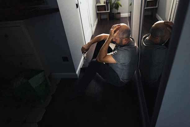 Silhouette of a Sad Man Sitting Alone in a Dark Hallway