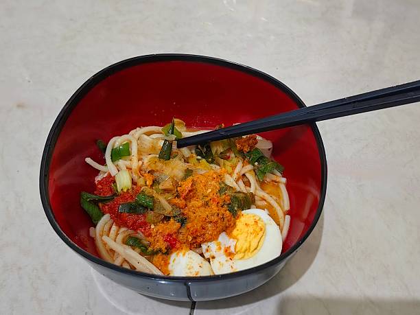 A bowl of spicy and delicious ramen with the addition of boiled egg.