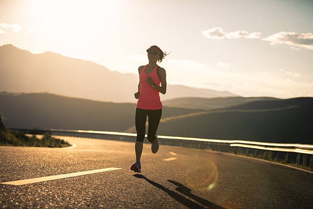 istock Woman runner running in sunset mountain road 2235864240