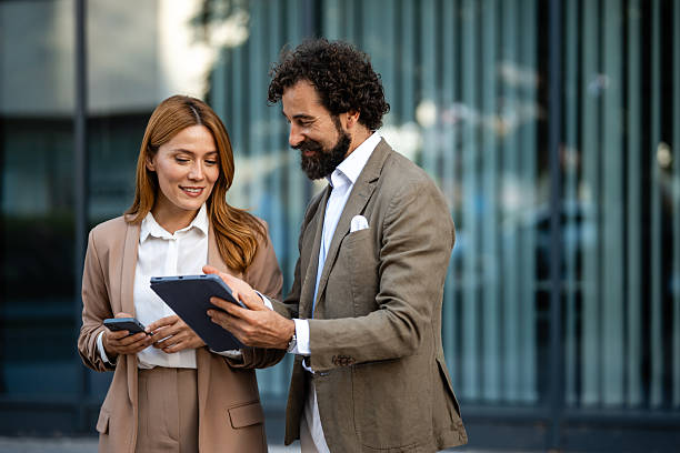 istock Businesspeople using digital tablet and smartphone outdoors 2235864295
