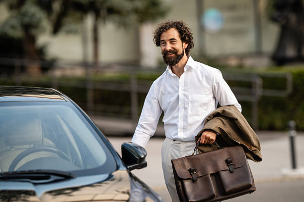 istock Businessman opening car door while holding briefcase and jacket 2235865333