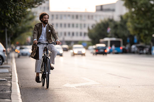 istock Businessman riding bicycle in city traffic during commute 2235865415