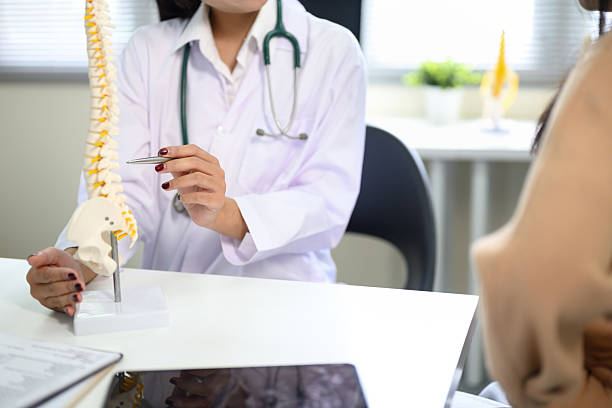 istock Doctor educating patient about spinal health and back pain issues 2235865508
