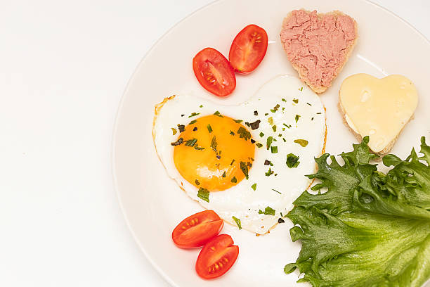 istock Fried eggs in the shape of a heart, bread with pate and chees. Romantic breakfast for Valentine's Day. 2235865930