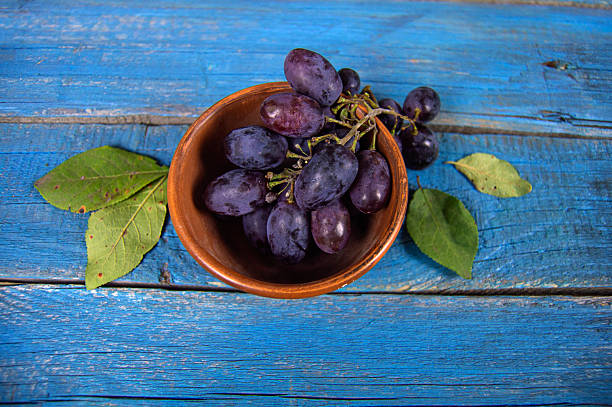 Ripe grapes lie on a blue wooden background