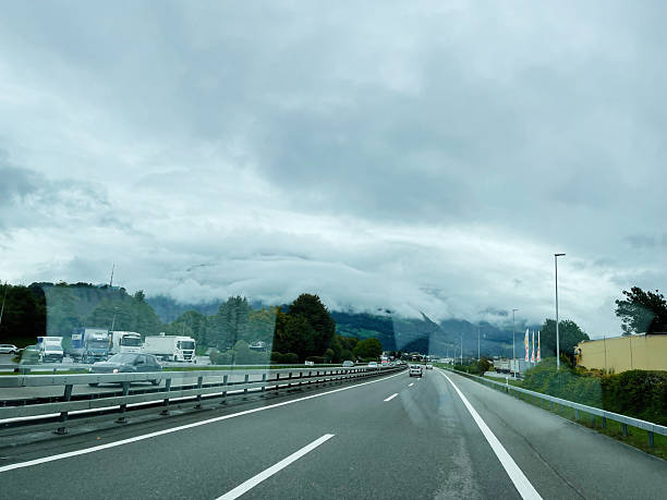 Cloudy highway view with vehicles in Switzerland against a mountain backdrop
