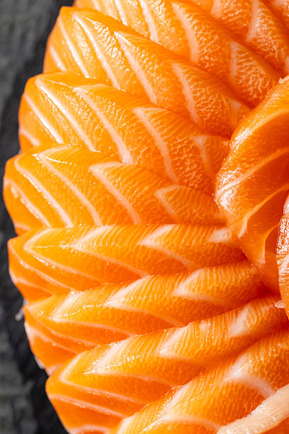 Close-up of Intricate Salmon Slice Pattern on Dark Background