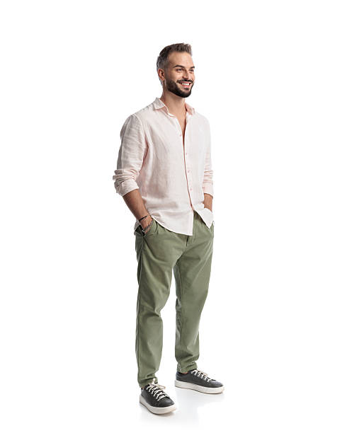 istock happy casual man holding hands in pockets, standing and smiling 2235872143