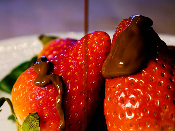 London UK, July 15 2025, Sliced Fresh Organic Strawberries With Broken Squares Of Milk Chocolate