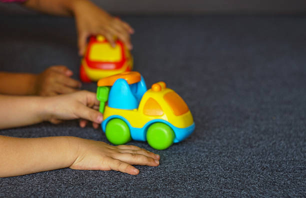 Little girls are playing with toy cars