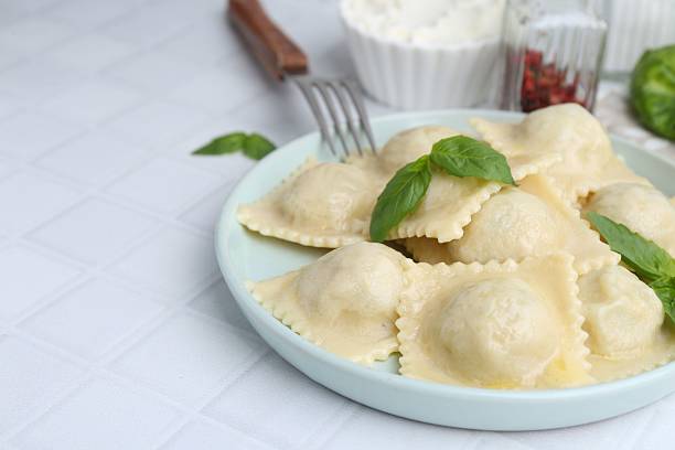 istock Delicious ravioli with cheese and basil served on white tiled table, closeup. Space for text 2235872835