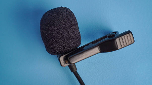 istock Black lavalier microphone with foam cover on blue background 2235875027