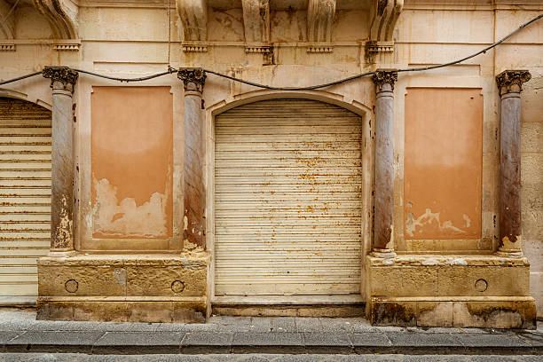 Weathered architectural details showcase the aged charm and history of a street facade located in the Sicilian town of Syracuse, Italy.