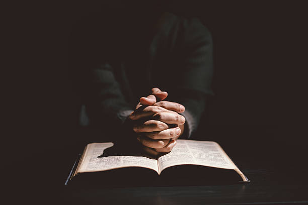 istock Hands folded in prayer on the Holy Bible, symbolizing faith, devotion, Christianity, hope, and spiritual strength. Concept of worship, meditation and trusting God Word. 2235876038