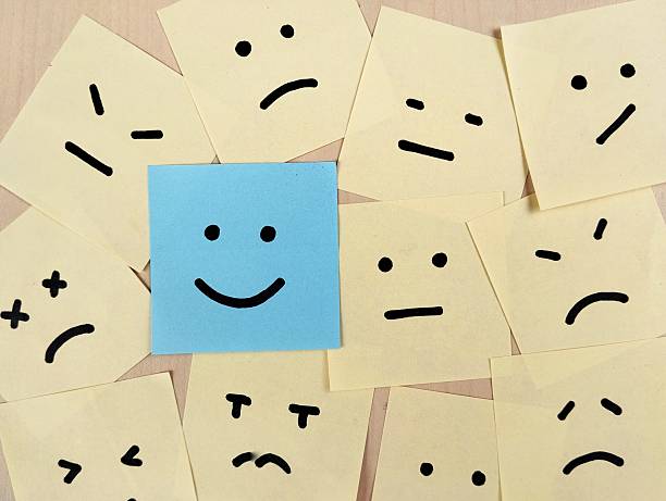 istock Hand drawn faces on sticky notes with on that stands out in a smile emoji, positive way concept 2235879387