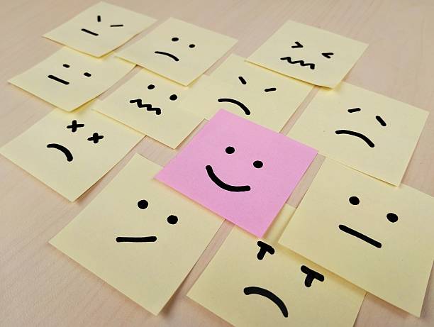 istock Hand drawn faces on sticky notes with on that stands out in a smile emoji, positive way concept 2235879392