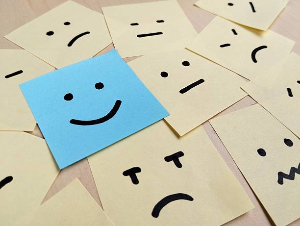 istock Hand drawn faces on sticky notes with on that stands out in a smile emoji, positive way concept 2235879394