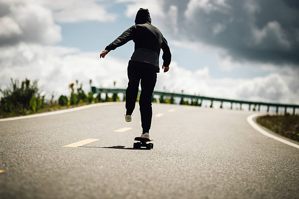 A person riding a longboard on asphalt