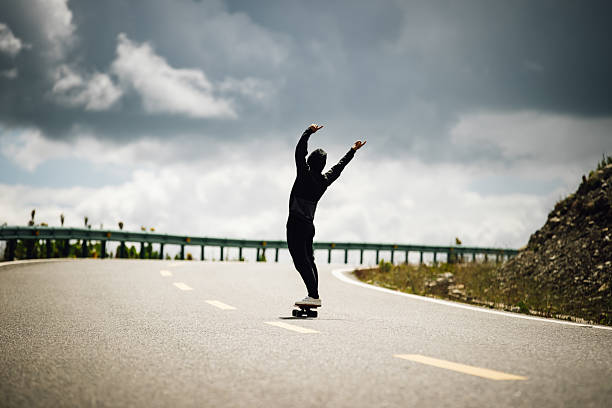 istock Skateboarder skateboarding on the mountain road 2235880416