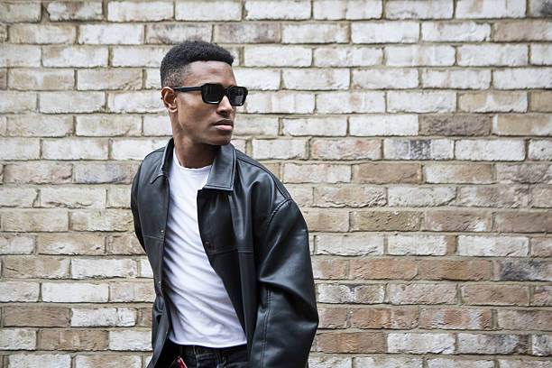 istock Confident and active young adult with a cool attitude by a brick wall 2235880767