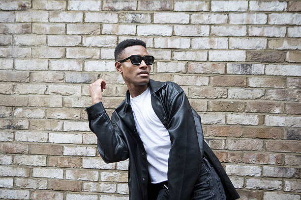 istock Confident and active young adult with a cool attitude by a brick wall 2235880774