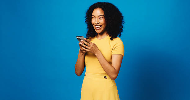 istock Laughing, woman and texting with smartphone, studio and communication with tech and blue background. Happy, person and funny joke on social media, mockup space and humor for message on mobile app 2235881006