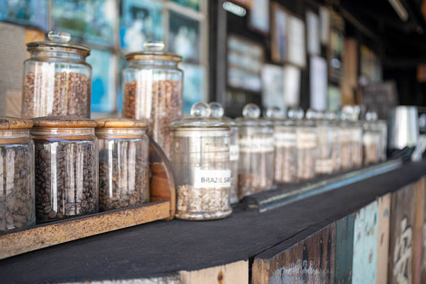 Aromatic roasted arabica and robusta coffee beans in glass small jars on bright orange background. Perfect coffee beans to make tasty coffee beverages such as espresso, americano, cappuccino, latte.