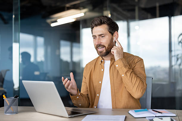 istock Man having a video call on laptop in a modern office setting 2235882728