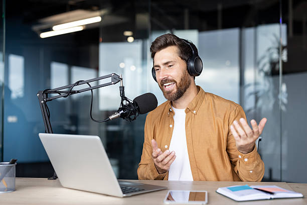 istock Man recording a podcast at a professional setup in a modern office 2235882759