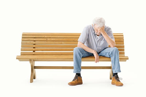 Tired lonely senior man sitting on a bench and thinking, isolated on white background