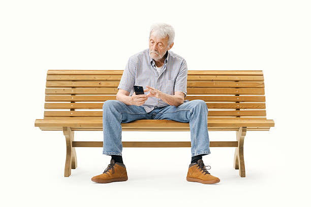 istock Elderly man sitting on a bench and using a smartphone 2235883003