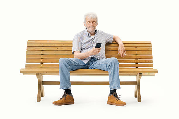 istock Happy senior sitting on a bench and using a smartphone 2235883015