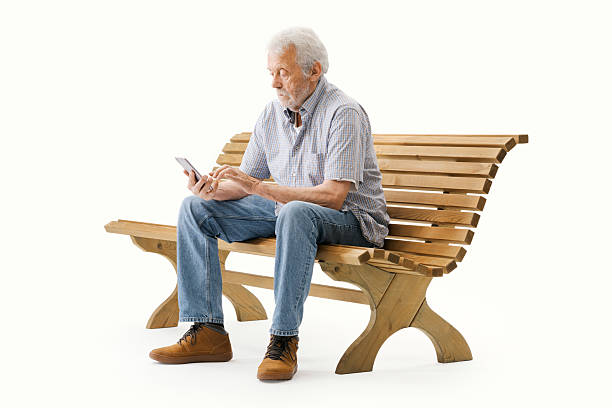 istock Elderly man sitting on a bench and using a smartphone 2235883098