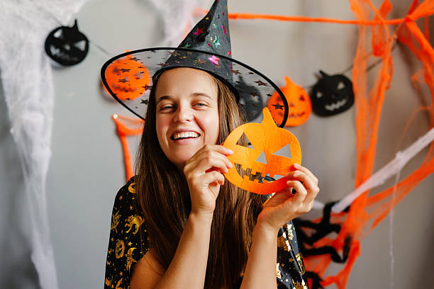 Brightly decorated space for Halloween featuring a cheerful witch with a pumpkin cutout, surrounded by colorful streamers and spooky decor