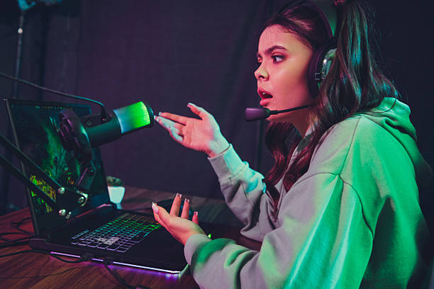 istock Young female streamer engaging in a vibrant live broadcast with headset and gaming setup during evening 2235884101